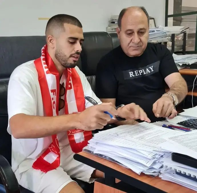 עילאי אלמקייס חותם על החוזה עם בני סכנין לצד היו"ר מוחמד אבו יונס