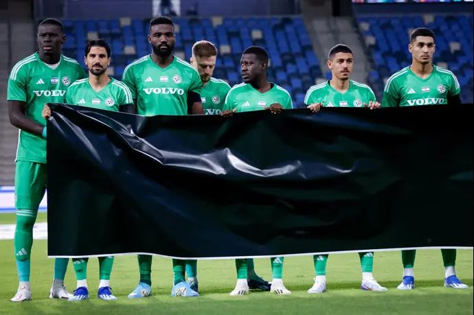 שחקני מכבי חיפה עם השלט למען החטופים, הזרים לא מחזיקים: פייר קורנו, פרנזי פיירו, עבדולאי סק