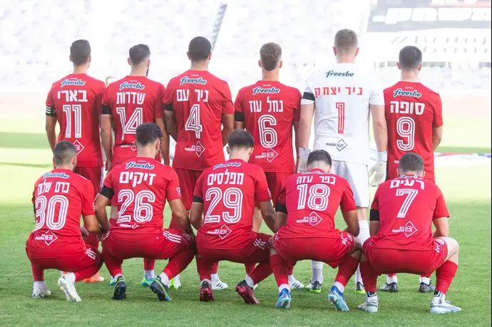 שחקני הפועל תל אביב עם שמות הישובים שהותקפו על הגב