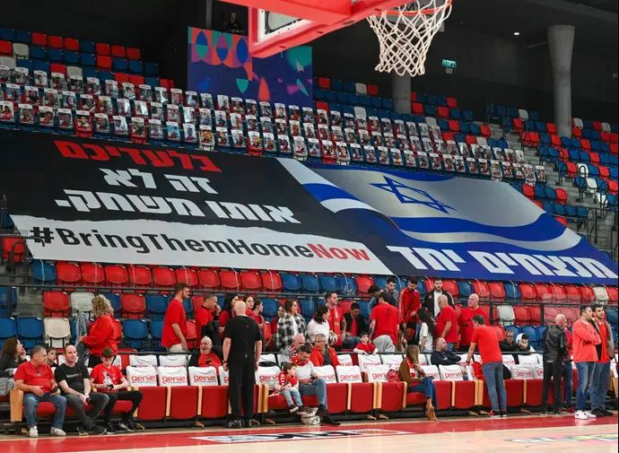 שלט ביציע היכל קבוצת שלמה בקריאה להחזרת החטופים מעזה