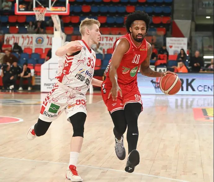 שחקן הפועל תל אביב בראיין אנגולה ליד שחקן הפועל גליל עליון יהל פלג