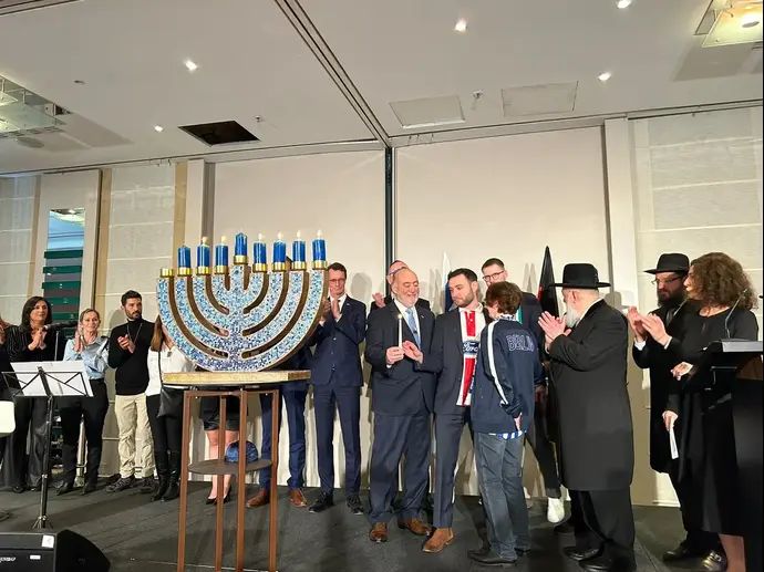 נציגי האוהדים של מועדוני הכדורגל של הרטה ברלין, ורדר ברמן וקלן, השתתפו בהדלקת נר שביעי של חנוכה בברלין