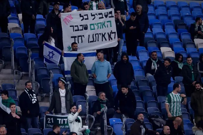 אוהדי מכבי חיפה עם שלט לזכר האוהדים שנרצחו