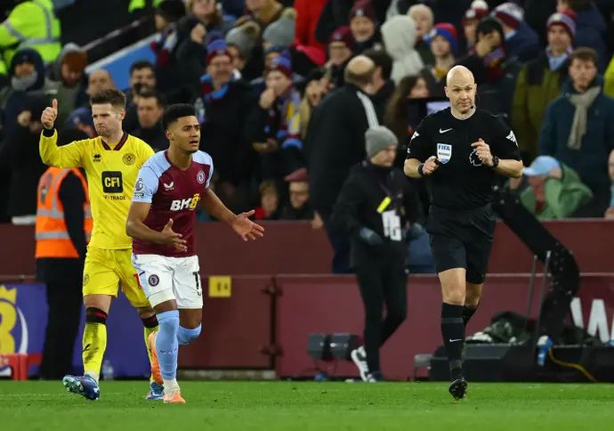 לאון ביילי, שחקן אסטון וילה לצד השופט אנתוני טיילור