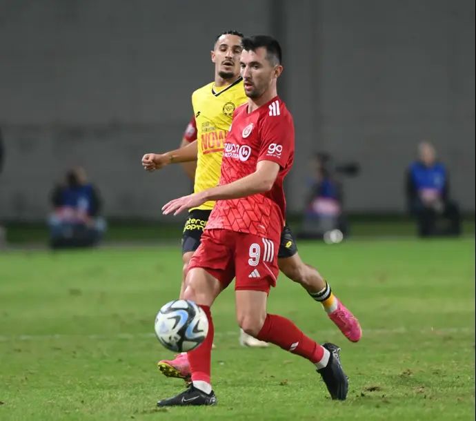 אלן אוז'בולט שחקן הפועל תל אביב לפני גיא מזרחי שחקן מכבי נתניה