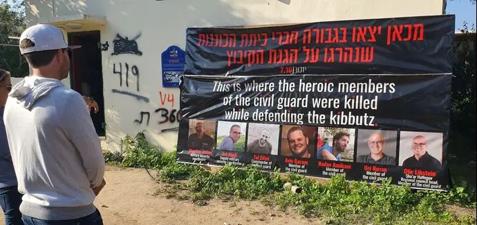 דניאל בלומן בכפר עזה מול תמונות נרצחי כיתת הכוננות