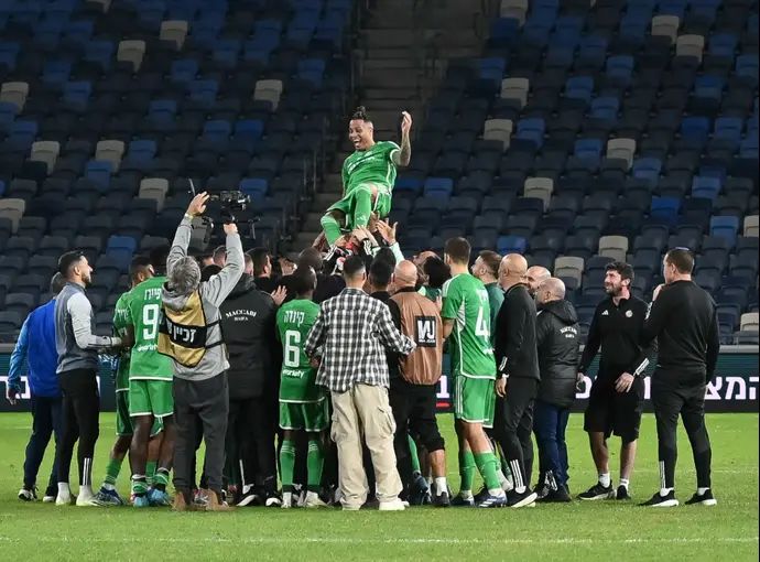 שחקני מכבי חיפה מניפים את צ'ארון שרי