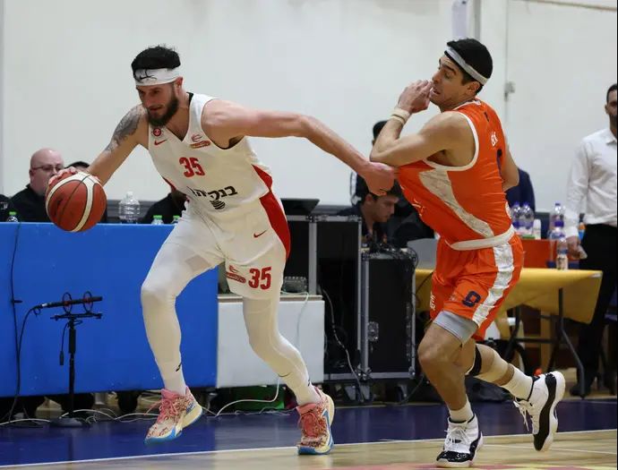 שחקן הפועל ירושלים זאק הנקינס ליד שחקן עירוני נס ציונה איתי שגב