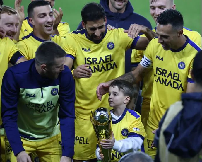 בנו של אסף חממי ז"ל מעניק את גביע הטוטו לשחקני מכבי תל אביב