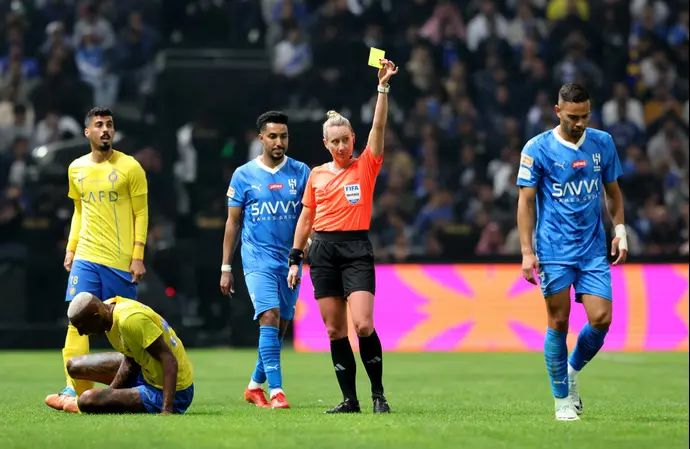 טורי פנסו שופטת אמריקנית שולפת כרטיס צהוב לעבר רנאן לודי שחקן אל הילאל