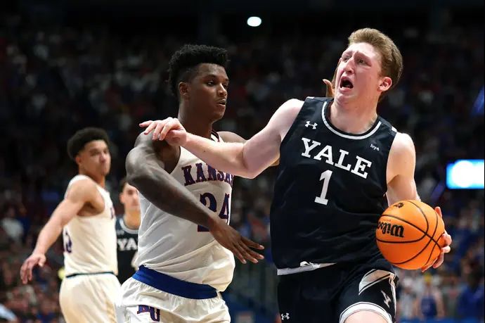 דני וולף, שחקן ייל, מול קיי ג'יי אדאמס, שחקן קנזס