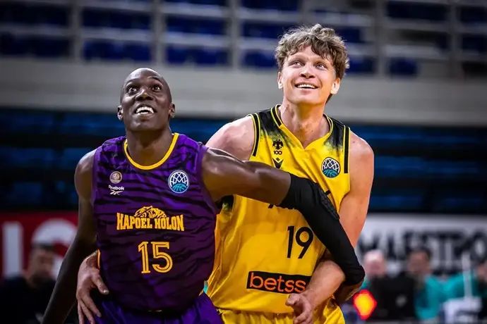 מינדאוגאס קוזמינסקאס שחקן א.א.ק אתונה מול קווין הרווי שחקן הפועל חולון