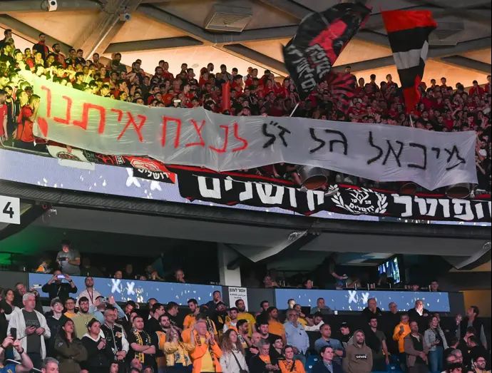 אוהדי הפועל ירושלים עם שלט לזכרו של מיכאל גל ז"ל