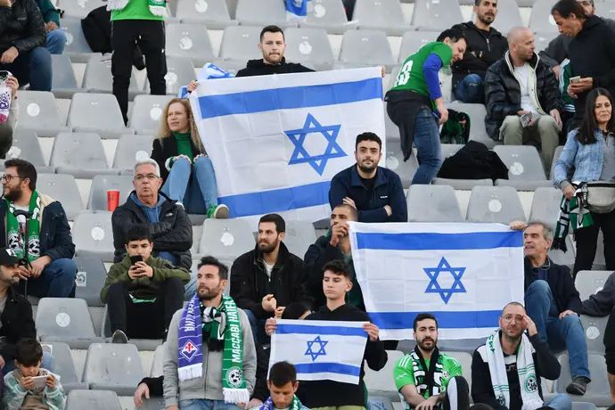 אוהדי מכבי חיפה עם דגלי ישראל ביציע מול פיורנטינה