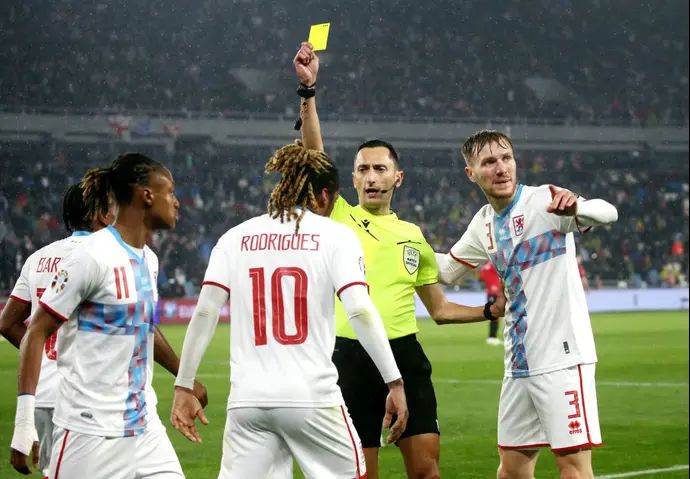 השופט הספרדי חוסה מריה סאנצ'ס מרטינס שולף כרטיס צהוב לעבר ז'רסון רודריגס שחקן נבחרת לוקסמבורג