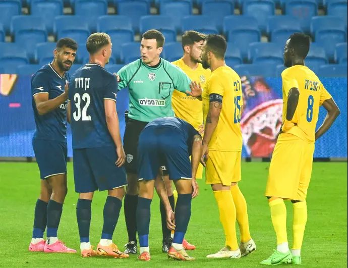 השופט אביב קליין עם שחקני מכבי הרצליה, שחקני עירוני קרית שמונה