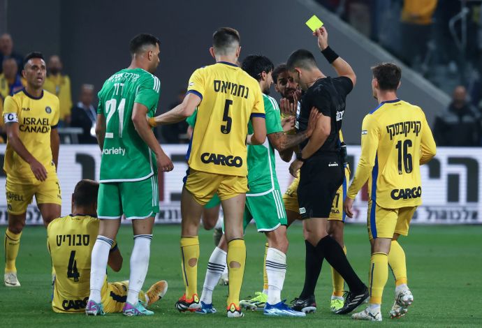 שחקני מכבי תל אביב עם השופט שניר לוי אחרי כרטיס צהוב לעבר ליאור רפאלוב שחקן מכבי חיפה