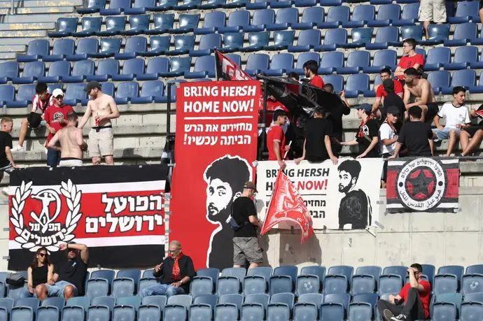 אוהדי הפועל ירושלים עם שלטים הקוראים לשחרורו של הרש גולדברג-פולין משבי חמאס