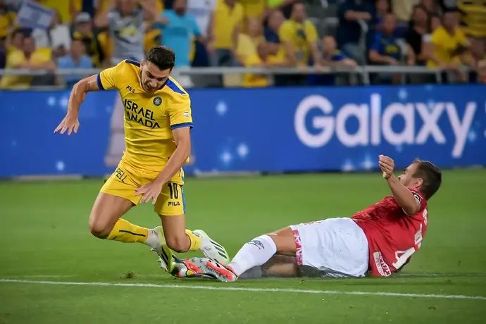 שחקן הפועל באר שבע, מיגל ויטור, מכשיל את שחקן מכבי תל אביב דן ביטון, לפני ההרחקה