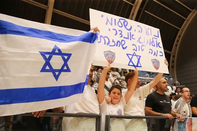 אוהדי עירוני קרית אתא עם שלט לכבוד הארבעה שחולצו מעזה