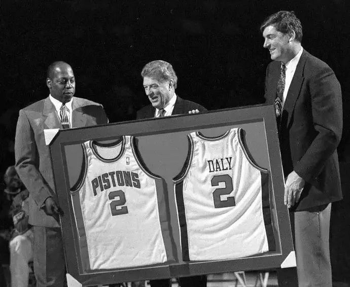 צ'אק דיילי מאמנה האגדי של דטרויט פיסטונס בטקס לכבודו ב-1997 עם ביל ליימביר, ויני ג'ונסון