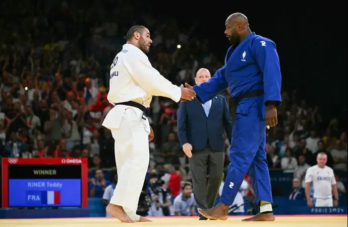 טדי רינר, ג'ודוקא צרפתי, לוחץ את ידו של גוראם טושישווילי הגאורגי