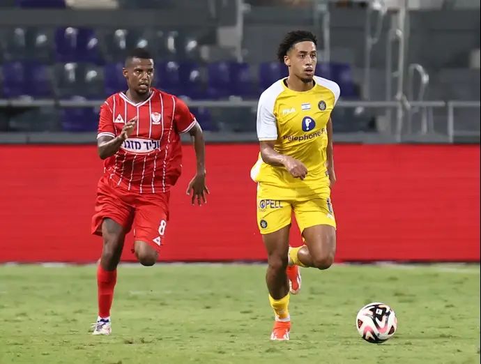 שחקן מכבי תל אביב טייריס אסנטה ליד שחקני בני סכנין מתנאל טדסה