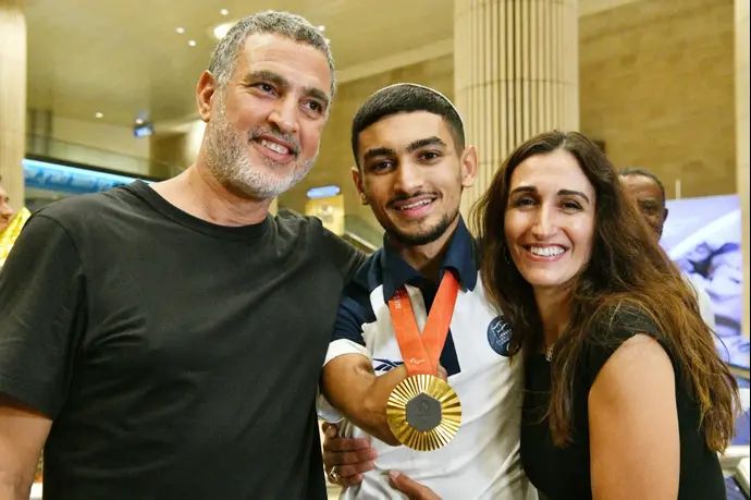 האלוף הפראלימפי אסף יסעור עם הוריו לאחר נחיתתו