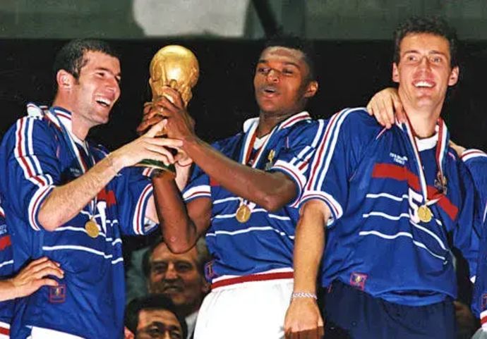 שחקני נבחרת צרפת זינאדין זידאן (שמאל והבלם מרסל דסאי (ימין) חוגגים זכייה בגביע העולם 1998