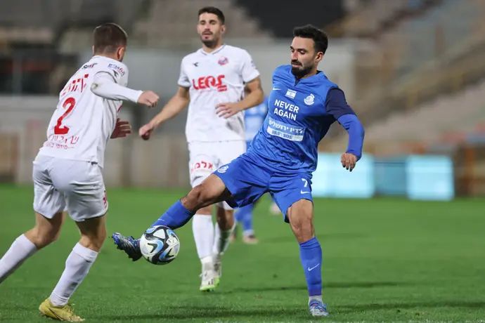 שחקן מ.ס. אשדוד מיכאל אוחנה ליד שחקן הפועל חיפה נועם בן הרוש