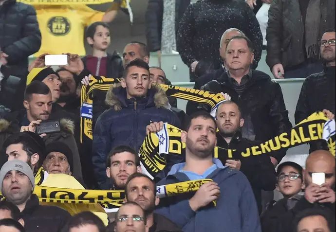 עומר אצילי שחקן בית"ר ירושלים (אמצע עם המעיל הסגול) עם אלעד גבאי