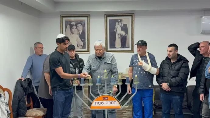 דור פרץ בהדלקת נר חנוכה בבית משפחתו של מני לוי