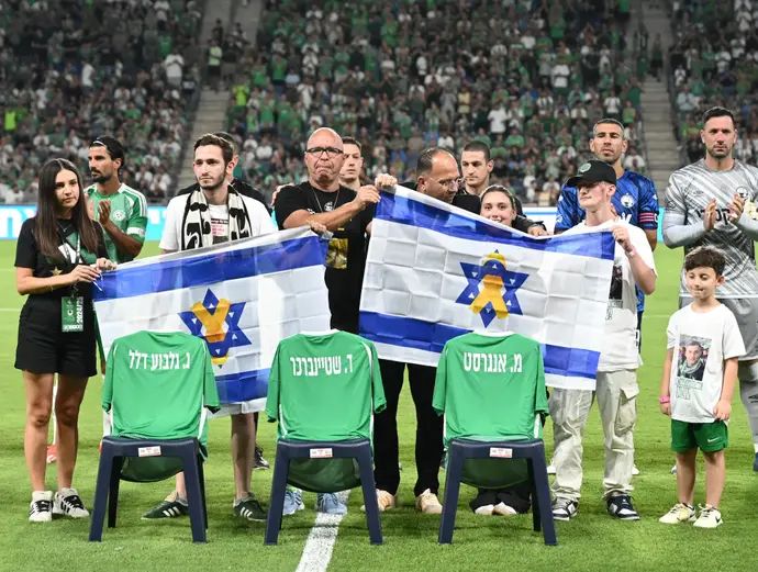 טקס של מכבי חיפה עם חולצות עם שמות החטופים, דורון שטיינברכר, גיא גלבוע דלאל, מתן אנגרסט