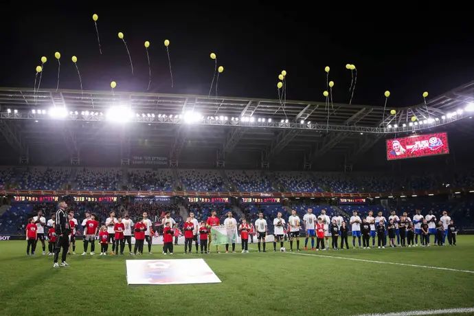 שחקני הפועל חיפה ומ.ס. אשדוד מפריחים בלונים צהובים אחרי שחרור רומי גונן ולמען שחרור כל החטופים והחטופות