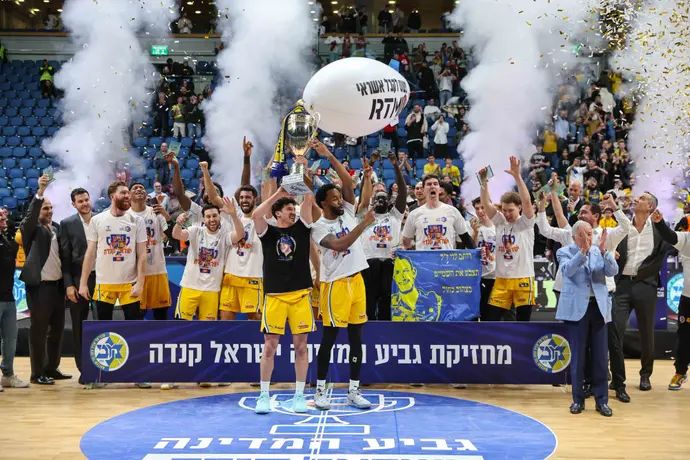 מכבי תל אביב מחזיקת גביע המדינה בכדורסל 2024/25, ליוואי רנדולף מניף עם ג'ון דיברתולומאו