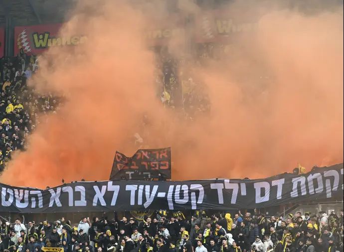 אוהדי בית"ר ירושלים עם פירוטכניקה כתומה לזכר נרצחי משפחת ביבס