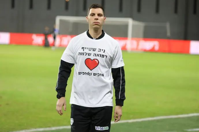 השופט הרביעי אביב אמדורסקי עם חולצה להחלמתו של ניב שטייף