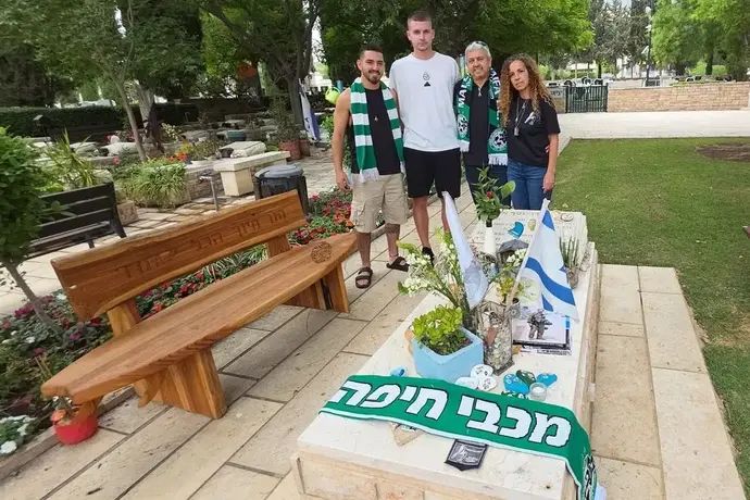 אולכסנדר סירוטה בבית הקברות עם משפחתו של אוהד הקבוצה, עידו אביב ז"ל, שנפל בקרב
