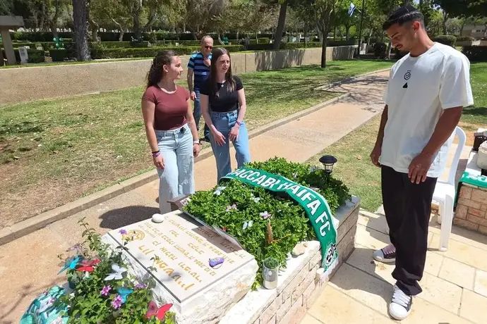 רועי אלימלך בבית הקברות עם משפחתו של אוהד הקבוצה, רון אפשטיין ז"ל, שנפל בקרב