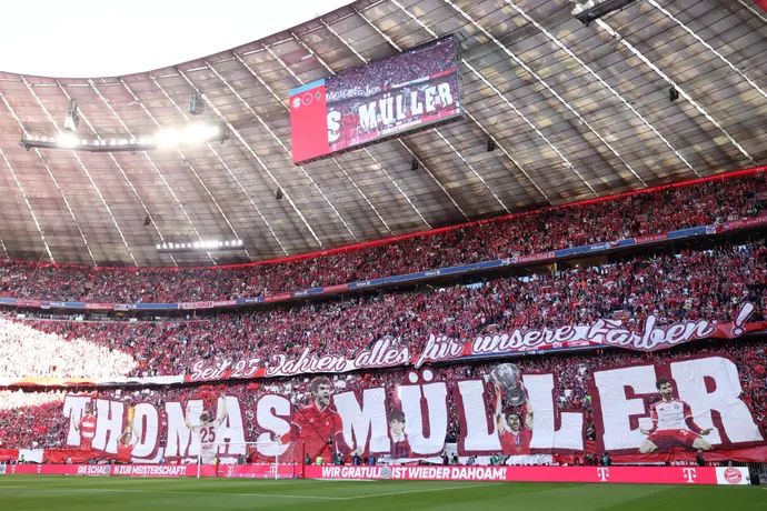 אוהדי באיירן מינכן עם שלט לכבוד תומאס מולר במשחק הבית האחרון שלו