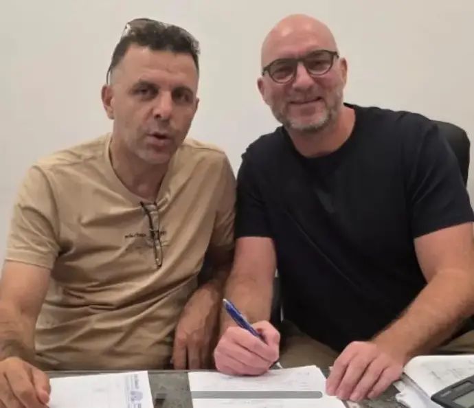 מילוש מנוילוביץ' (מימין) חותם על החוזה כמנהל המקצועי של בני סכנין