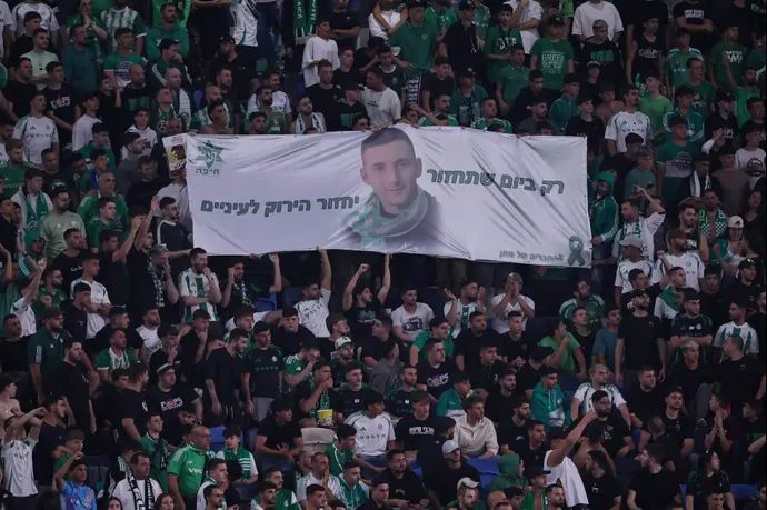 אוהדי מכבי חיפה עם שלט להשבתו של החטוף מתן אנגרסט