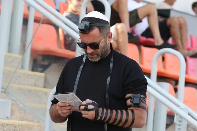 יקיר שוורץ בעלים הפועל חדרה מניח תפילין במגרש