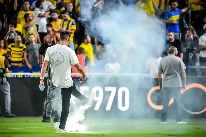 יואב זיו מנהל מכבי תל אביב בועט בזיקוק שנזרק לכר הדשא