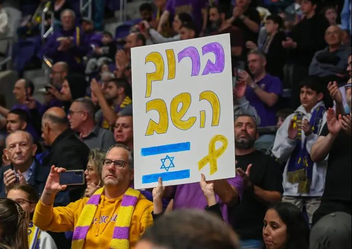 שלט במשחק של הפועל חולון לחזרתו של בר קופרשטיין