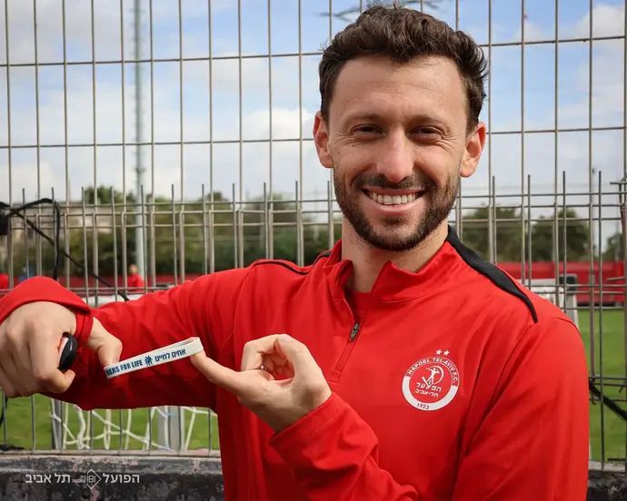 עומרי אלטמן שחקן הפועל תל אביב עם הצמיד של עמותת "אחים לחיים"