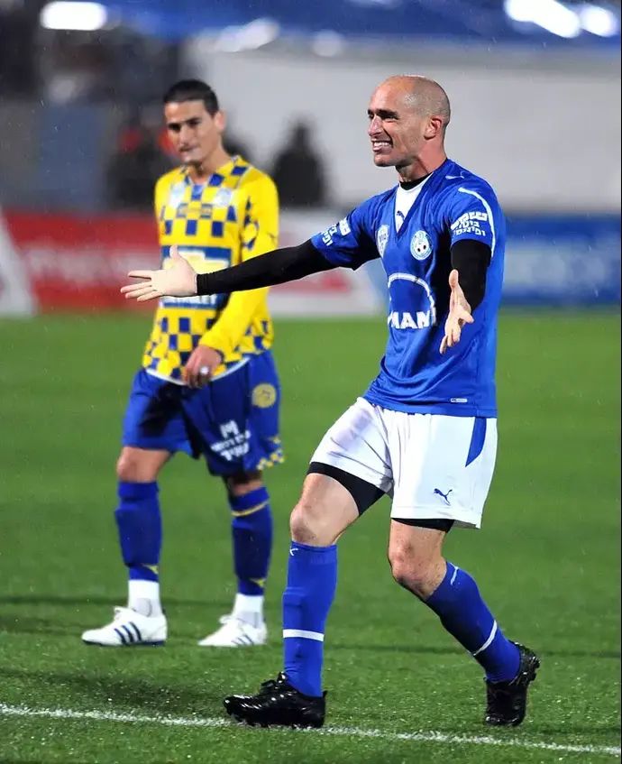 מגן הפועל פתח תקוה, אורי אוזן, חוגג שער ליד שחקן מכבי תל אביב, מאור בוזגלו המאוכזב.