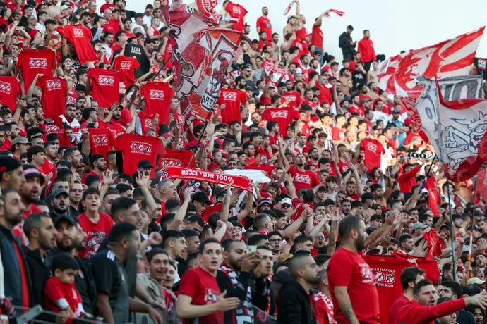 אוהדי הפועל תל אביב עם חולצות המחאה ביציע