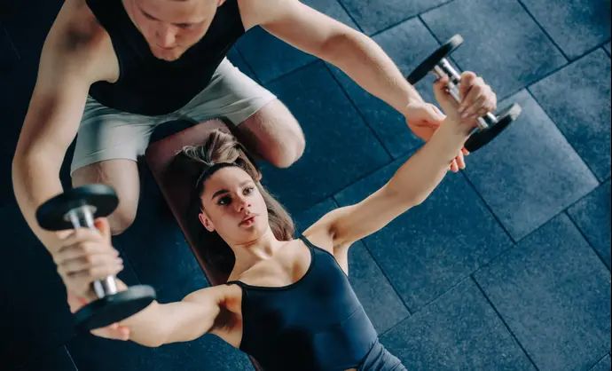 מאמן כושר ומתאמנת בחדר כושר