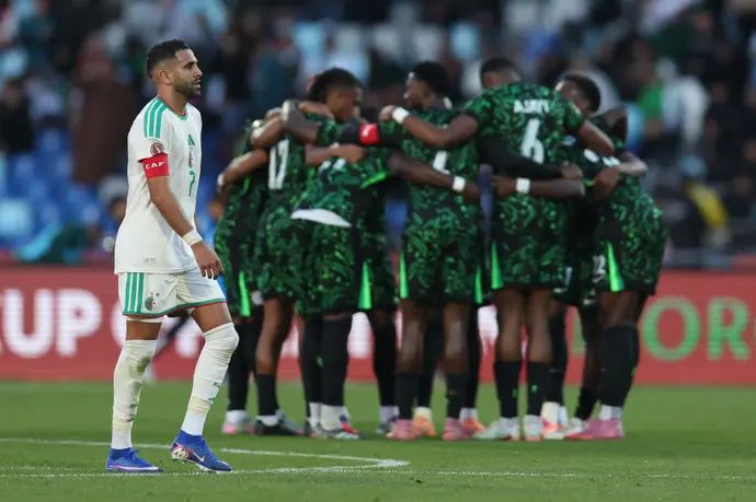 שחקן נבחרת אלג'יריה, ריאד מחרז, כשברקע שחקני נבחרת ניגריה חוגגים